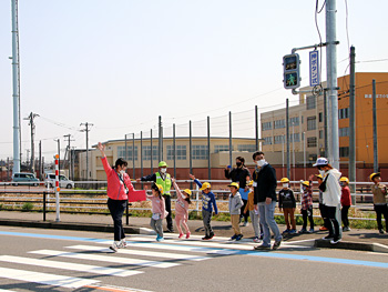 手を挙げて横断歩道を渡る児童