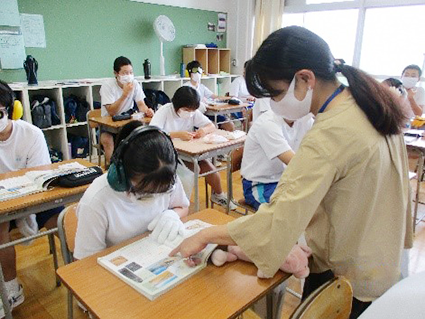 巻東中学校の教室で講義が行われている写真　女性の講師が教科書を指さしている