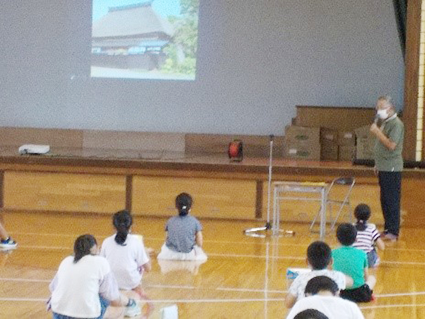 巻南小学校の生徒が体育館で地域の人から講義を受ける様子の写真