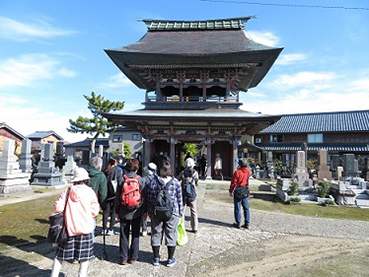 まちの魅力を探訪の様子　まち歩きで立派な仏閣を眺めている様子