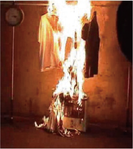 ストーブの上に干した洗濯物に引火し、火災が起きている写真