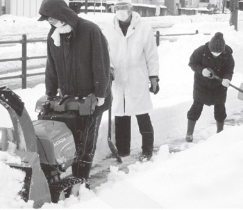 写真　車道だけでなく歩道も地域住民が協力して除雪を行っている。