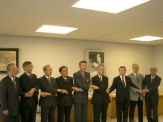 握手する篠田市長と8大学の出席者