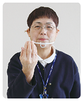 手話通訳者・鈴木さんが胸の前で指を揃えて手の平を内側している写真