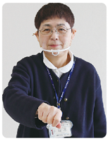 手話通訳者・鈴木さんが握った手を前に出している写真