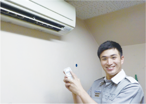 職員がエアコンのスイッチを押している写真