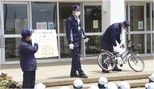 西蒲区交通指導員が児童に自転車の乗り方を説明している写真